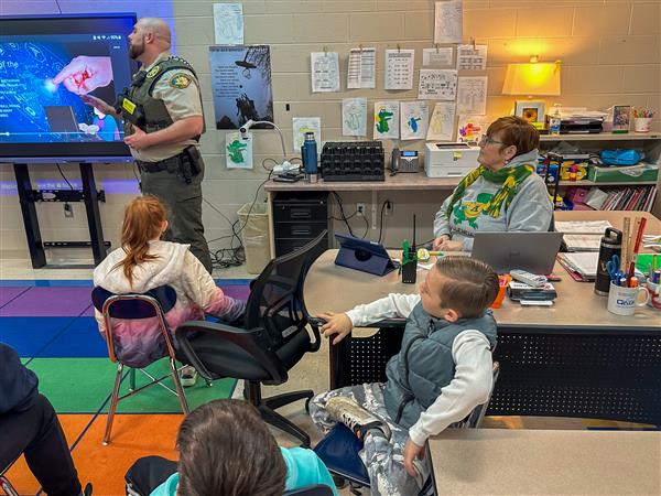 police officer talking to class of students